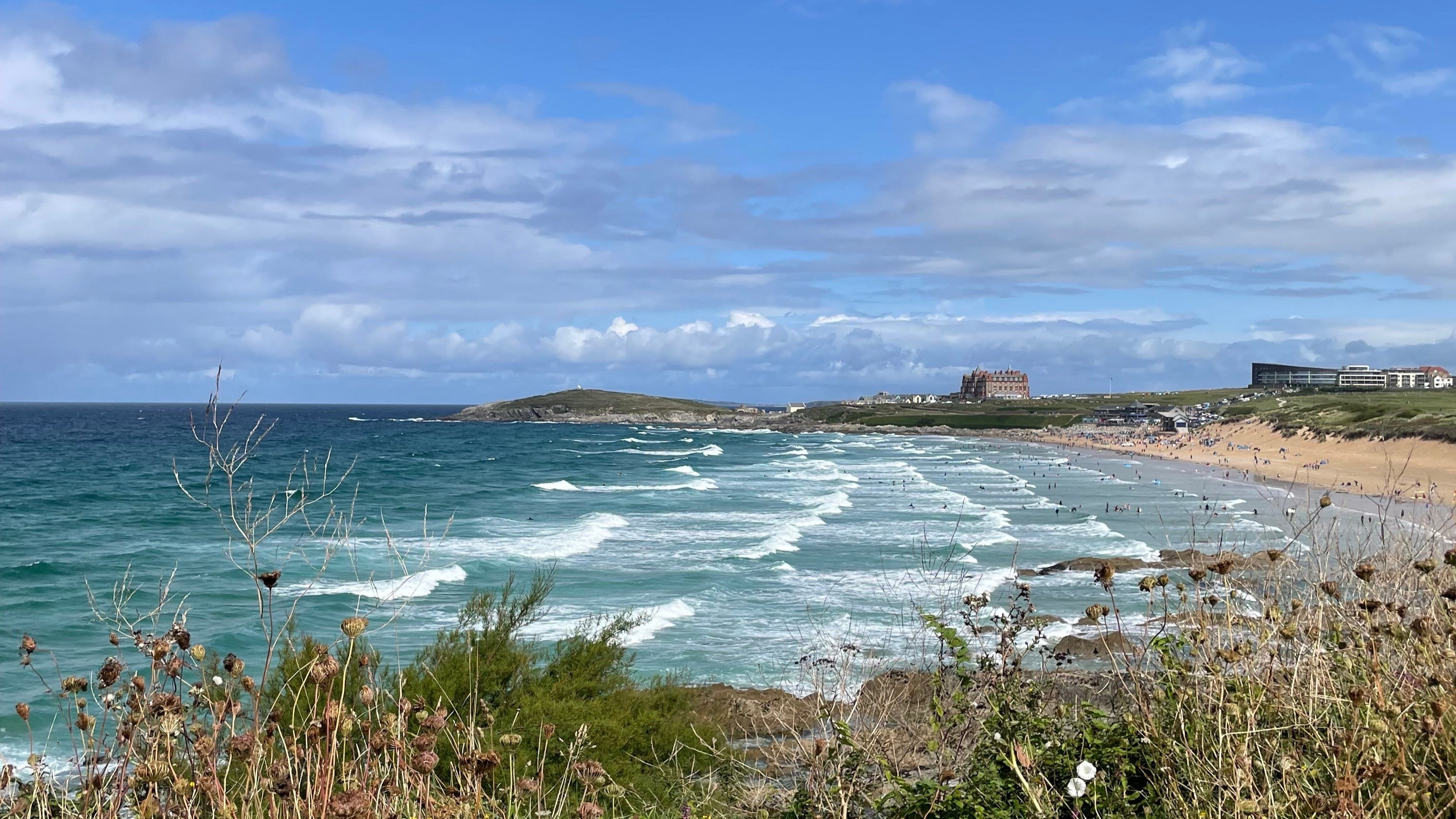 Scenic view of Fistral beach and ocean with a clear blue sky.
